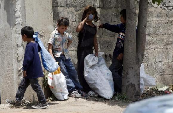 Syrian refugee children collect plastics as they stand along a street in south of Sidon southern Lebanon June 10 2014. Reuters