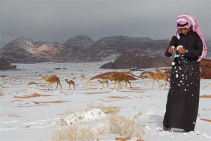 A Saudi man plays with snow after a heavy snowstorm in the desert, near Tabuk