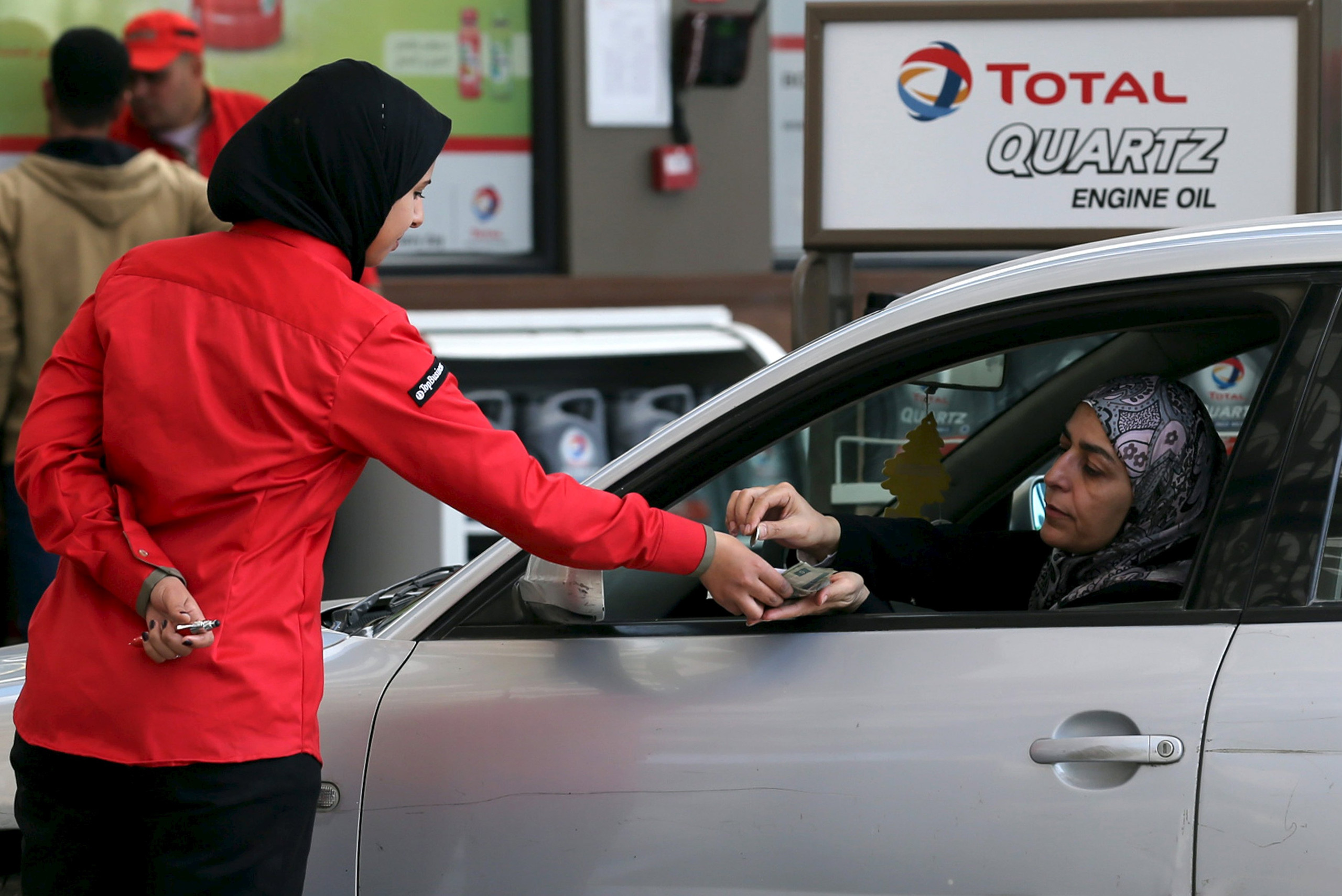 A female employee is seen at work at a petrol station in Cairo