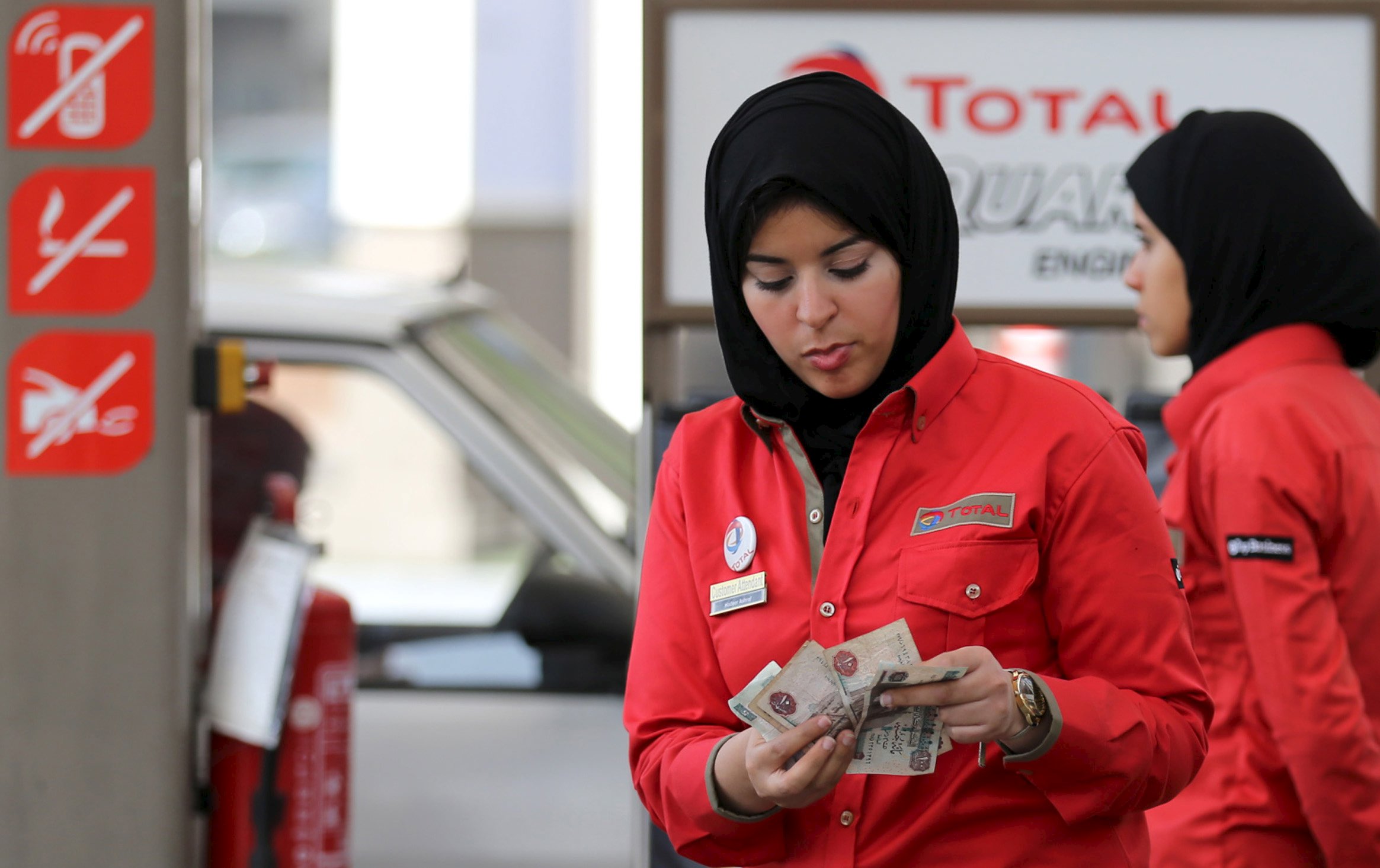 A female employee is seen as she works at a petrol station in Cairo