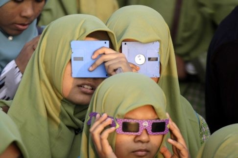 Régi floppy lemezeken keresztül nézik a napfogyatkozást indonéz diákok.