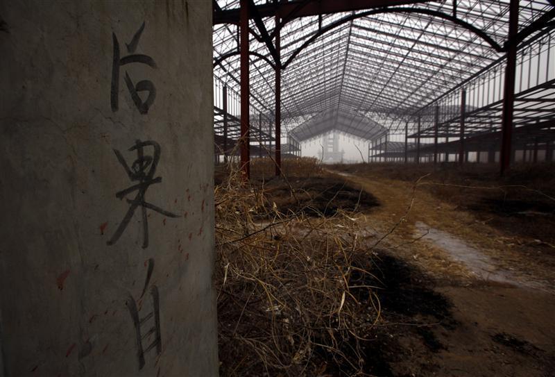 Writing on a gate is seen at an abandoned building that was to be part of 'Wonderland', on the outskirts of Beijing